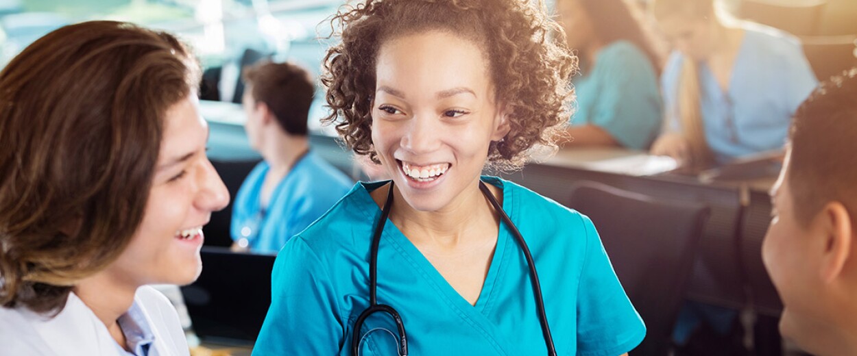 Image of three nurses smiling and talking to one another