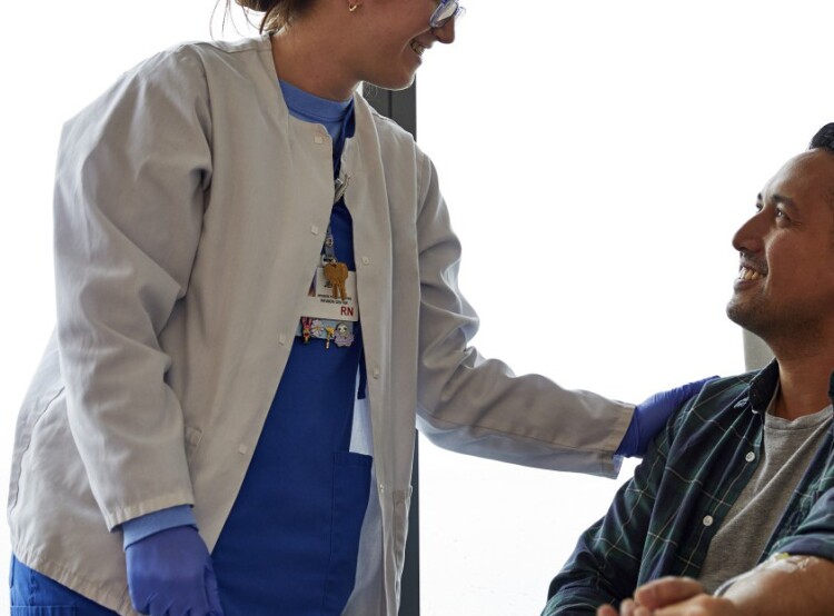 Female nurse smiling and talking to a male patient