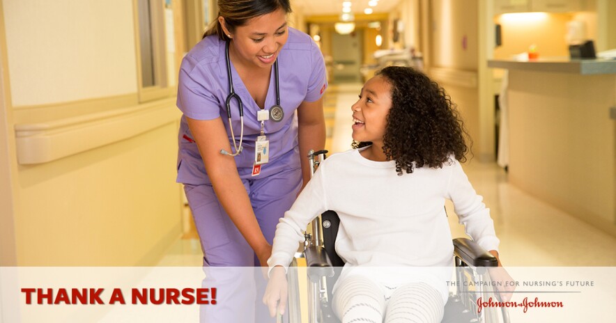 Female nurse in scrubs helping a young smiling female patient in a wheelchair