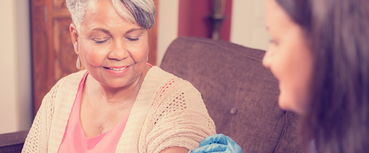 Image of female nurse preparing to give a shot to a female patient