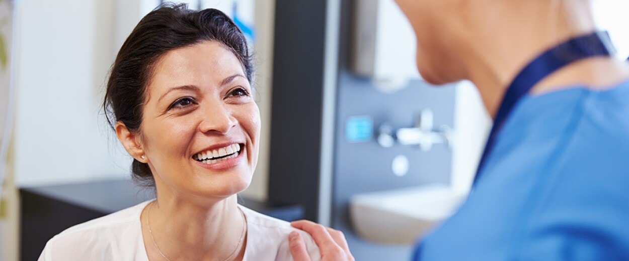 Female patient smiling and talking to female nurse