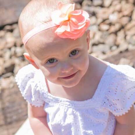 A baby smiling and looking up at the camera