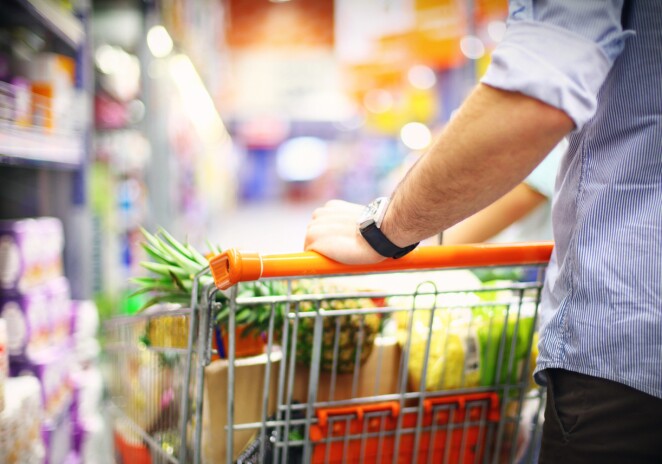 Close up of man pushing grocery cart full of produce and food