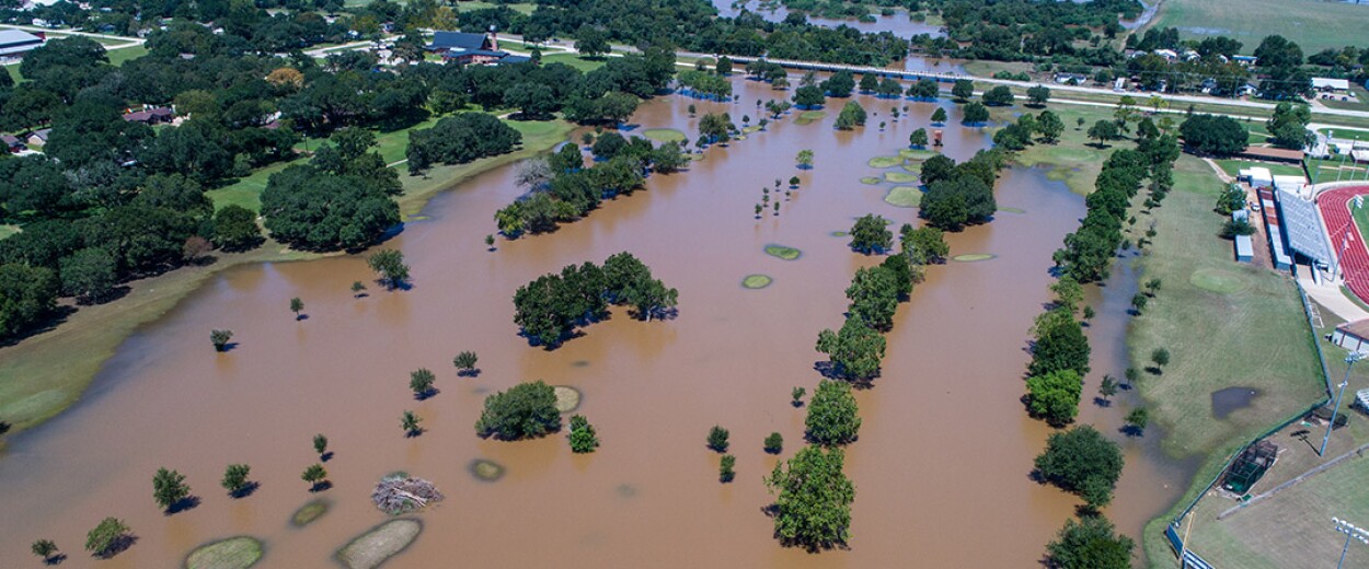 Birdseye view of flooded land next to a school track