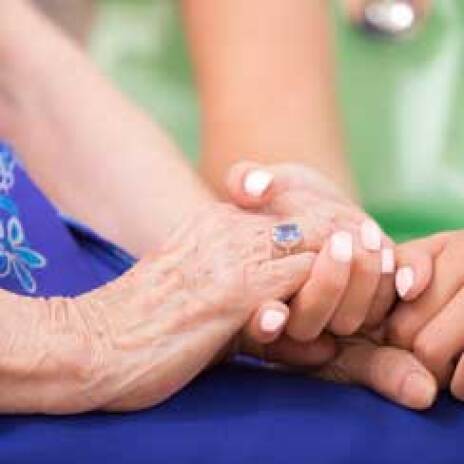 Two pairs of hands clasped together