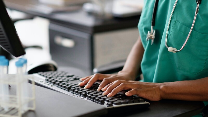 nurse typing on a computer keyboard
