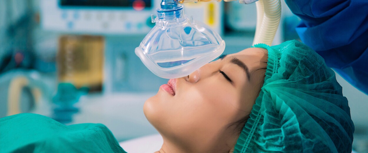 Woman in scrubs an hairnet about to receive anesthetics