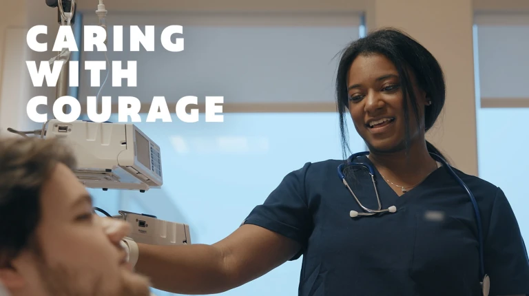 female nurse at patient's bedside from video still taken from "Caring with courage" film series