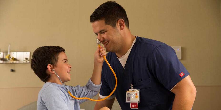 Male nurse in scrubs young male patient play with the stethoscope