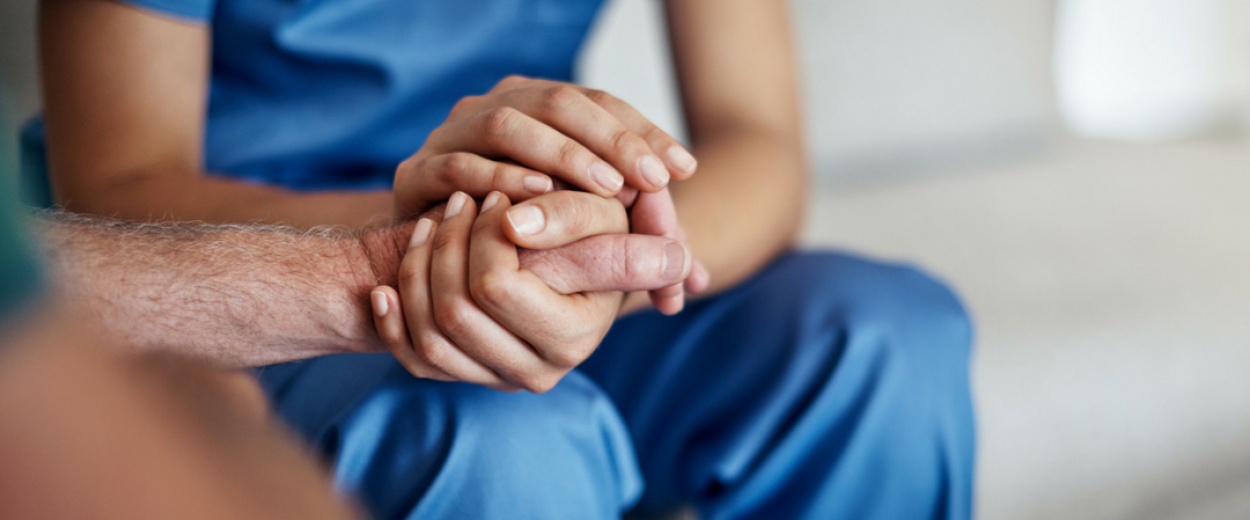 Close up of two pairs of hands clasped together