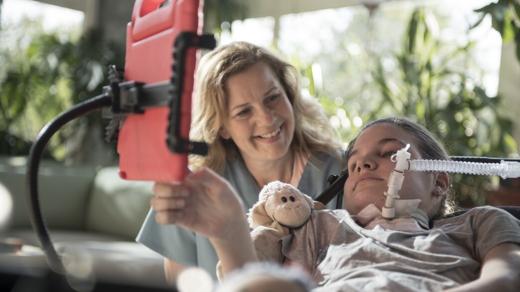 Female nurse smiling and taking care of female patient in an outdoor setting