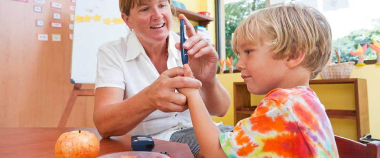 Female nurse helping young male diabetes patient take his blood sugar