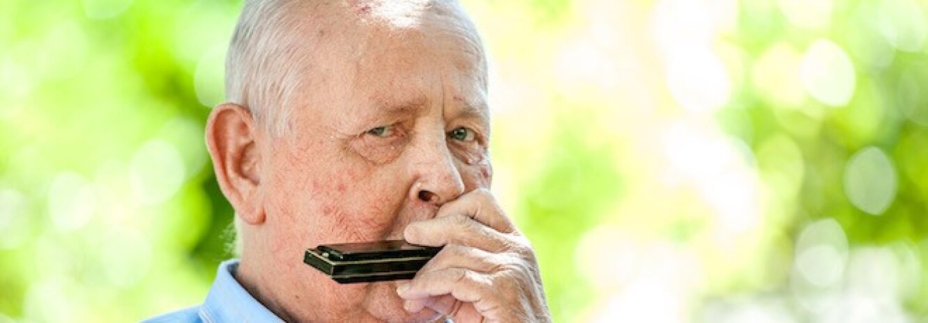 Elderly man playing the harmonica